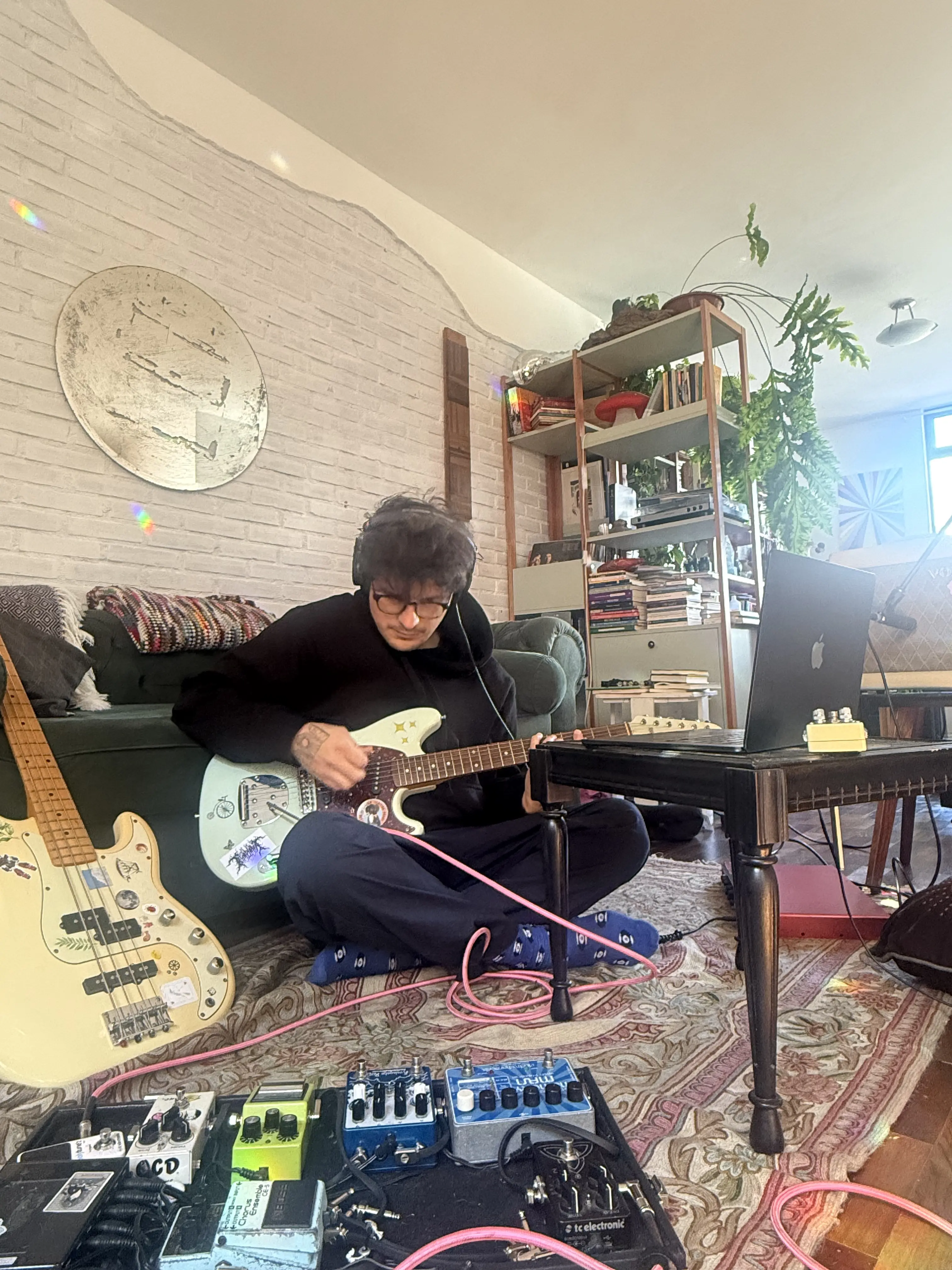 Uma foto de cima de uma mesa com instrumentos tipo teclados e um computador laptop